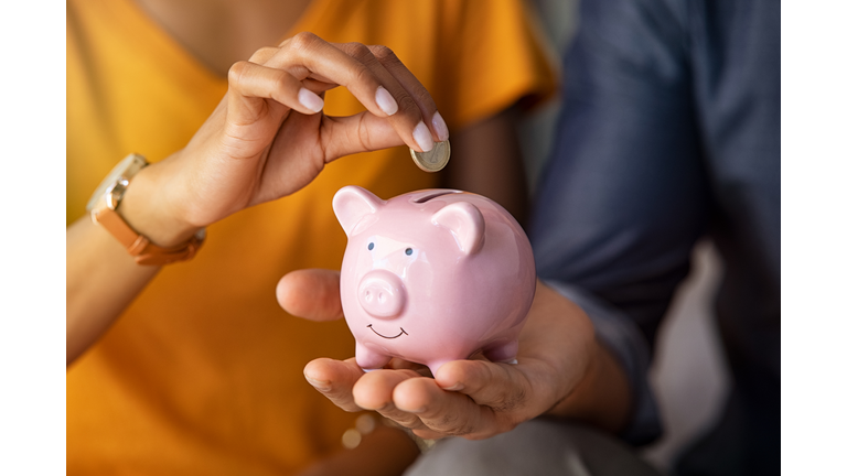 Couple saving money in piggybank