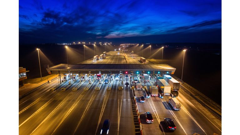 Aerial drone view on toll collection point on motorway at night.