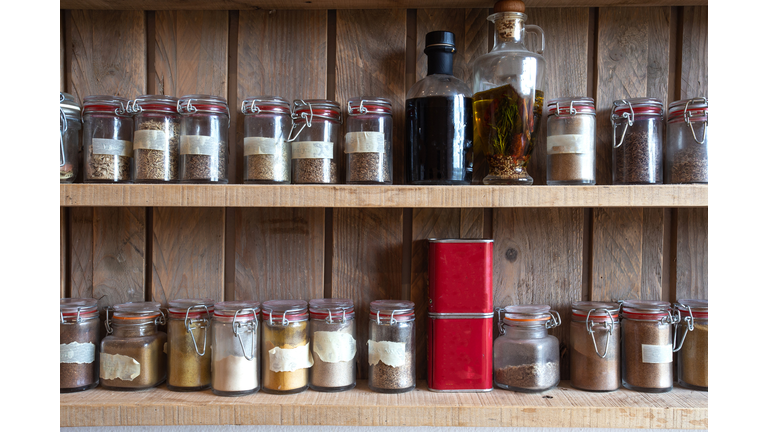 Bottles with spices and seasonings in wooden rack. Various different organic herbs for in the kitchen vintage look
