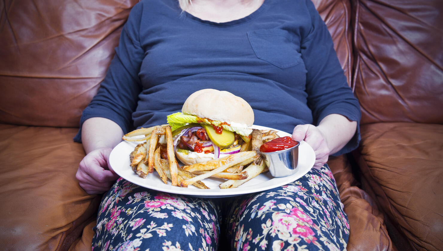 Overweight woman with a large unhealthy meal