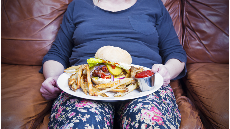 Overweight woman with a large unhealthy meal