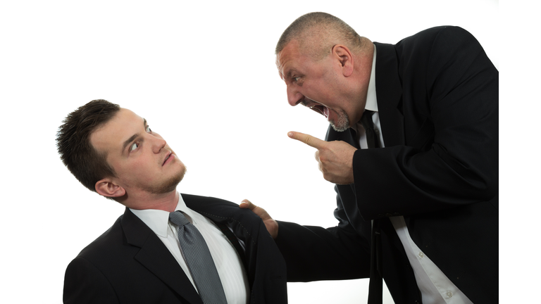 Businessman screaming and fighting at a young colleague