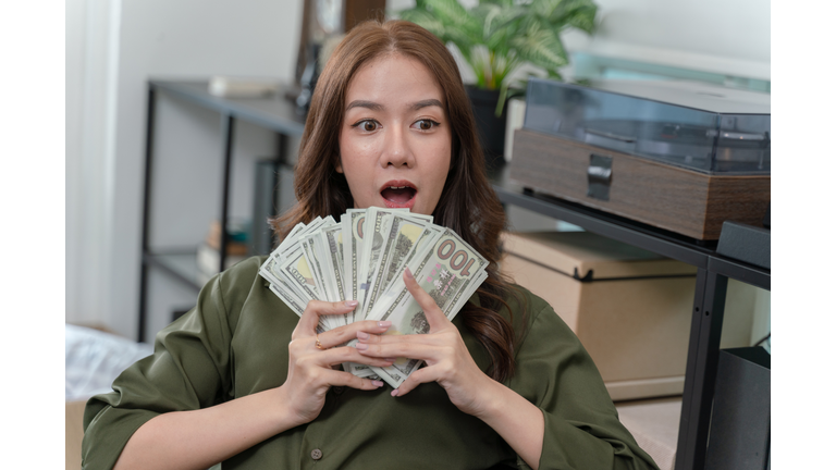 A woman is holding a bunch of money in her hands