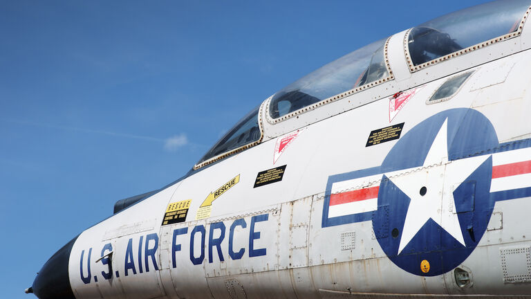 Jet fighter cockpit against sky