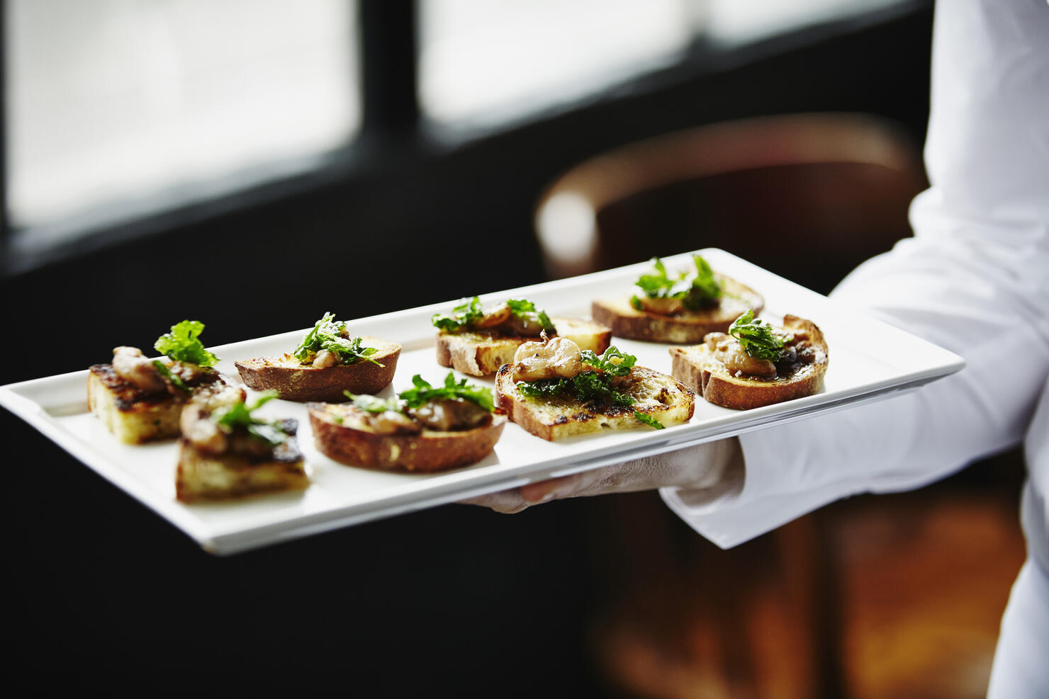 Waitress holding platter of organic appetizers