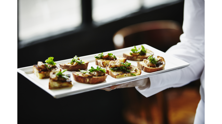 Waitress holding platter of organic appetizers