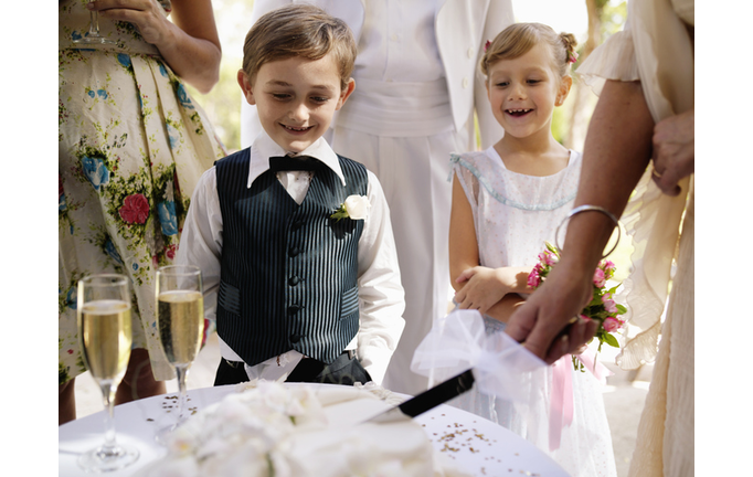 Pageboy and flowergirl (6-7)watching wedding cake being sliced