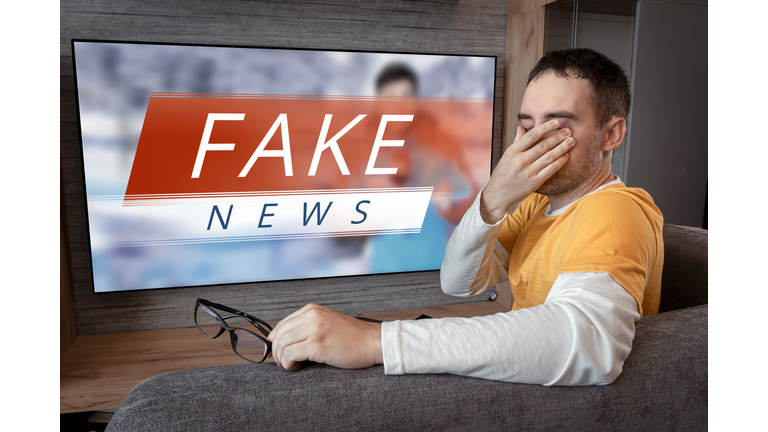 lies of tv propaganda mainstream media disinformation, A fake news report. viewer is watching TV and doesn't believe in fake news. man closes his eyes not to watch the lies on TV.