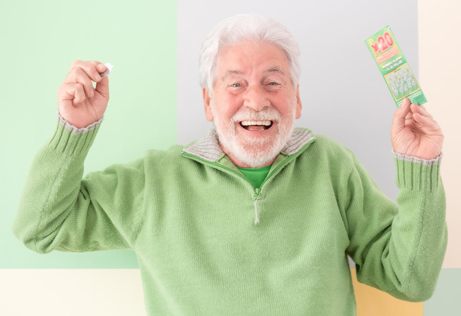 Happy caucasian white-haired senior man doesn't believe his eyes holding filled winning lottery ticket and celebrating victory. Lucky excited smiling mature man won a jackpot.