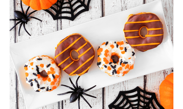 Halloween donuts above view table scene on white wood