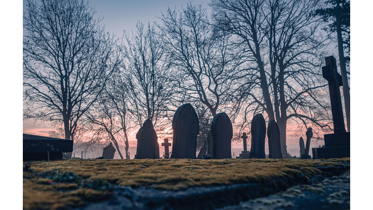 Headstones in a misty graveyard.