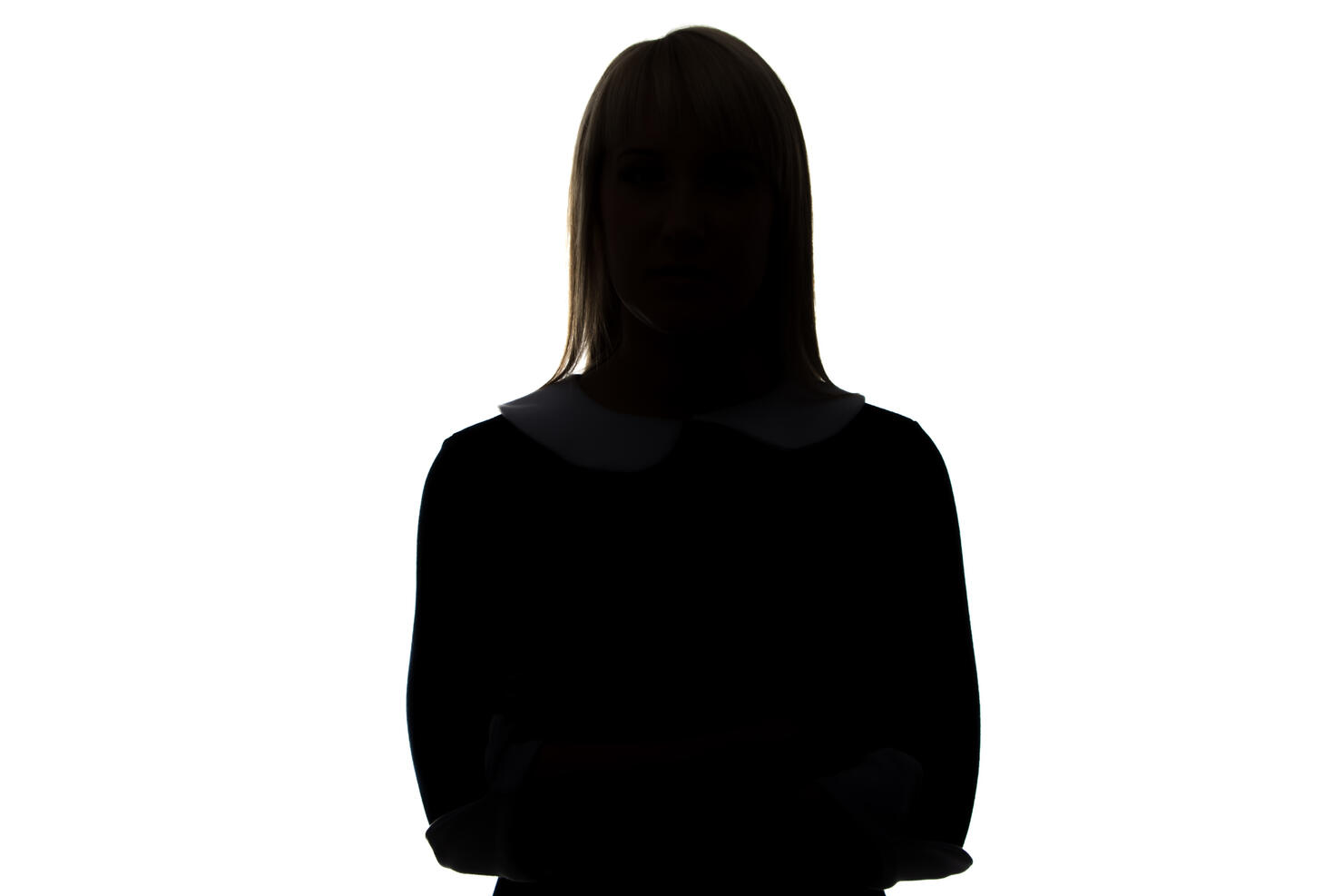 Silhouette of woman in dress with arms crossed