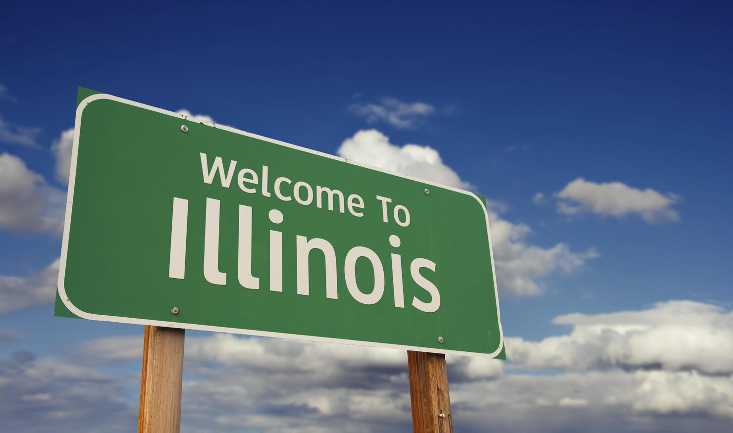 Welcome to illinois green road sign over blue sky with some clouds
