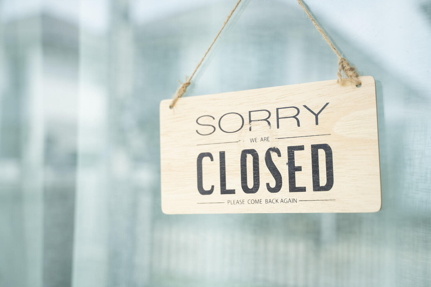A glass door with "closed" store sign.