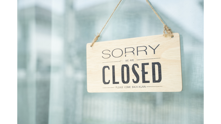 A glass door with "closed" store sign.