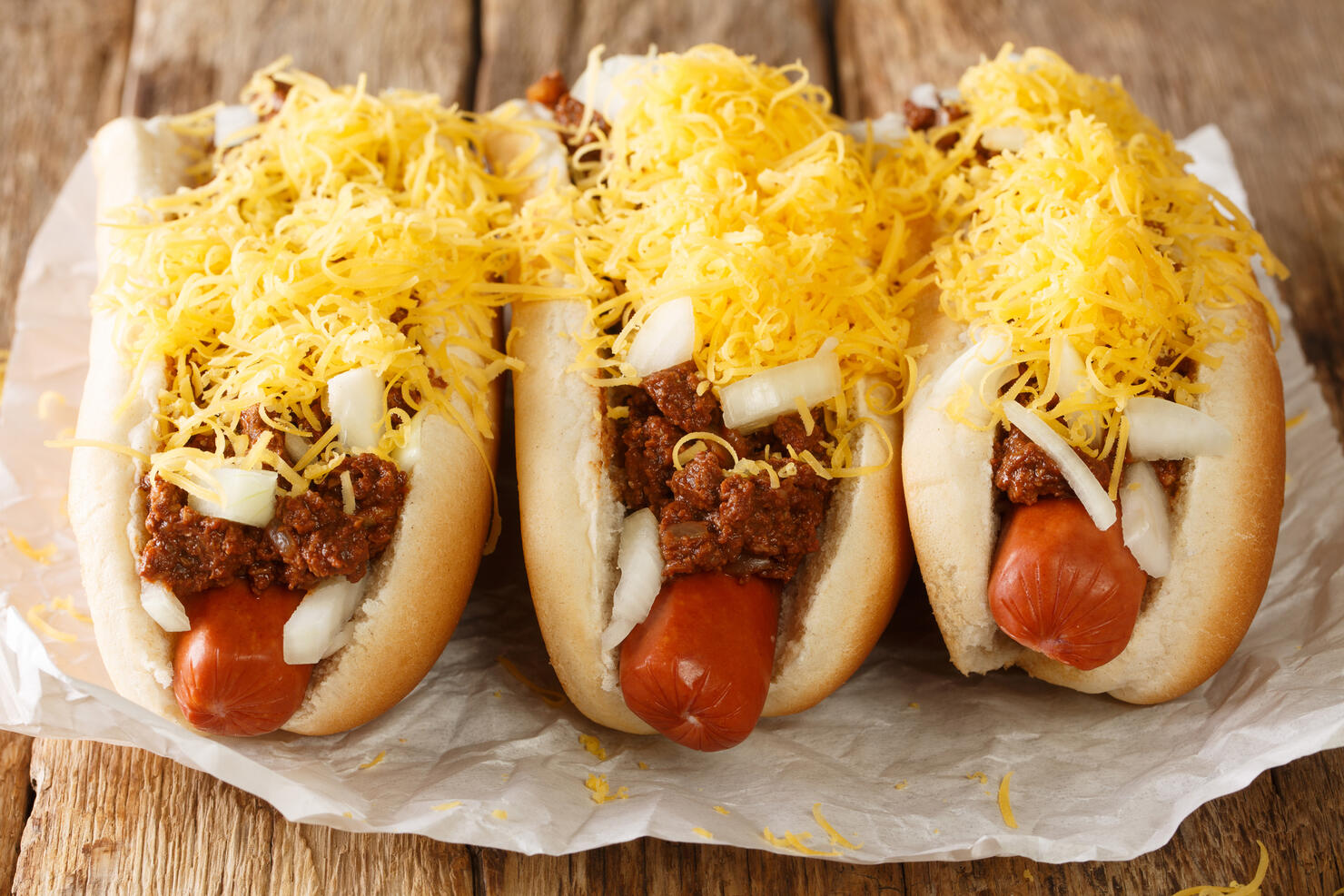 American Cincinnati Chili hot dog closeup in the paper. Horizontal