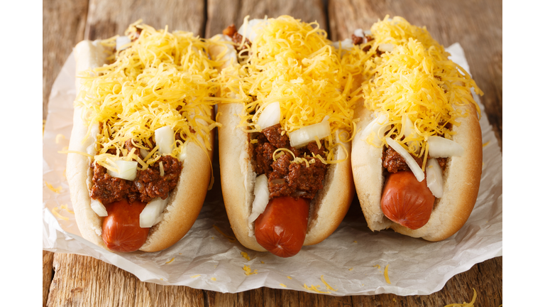 American Cincinnati Chili hot dog closeup in the paper. Horizontal
