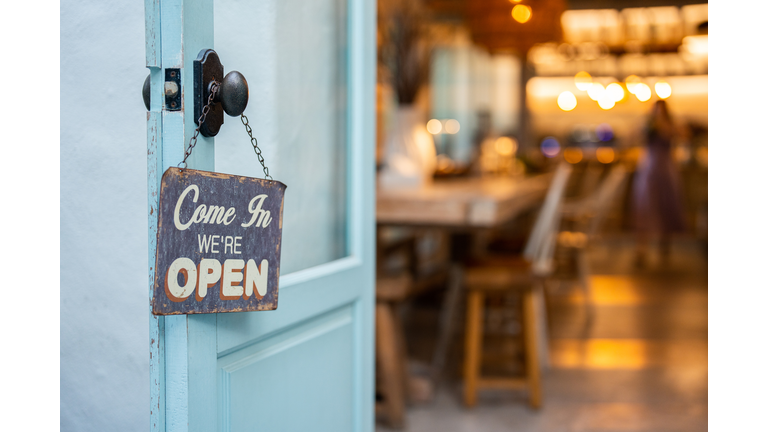 Open sign on cafe hang on door at entrance.