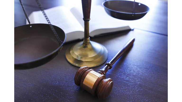 Gavel Rests In Front of Justice Scale And Open Law Book