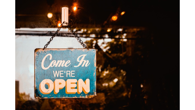 Come In We're Open sign on door of coffee  shop.