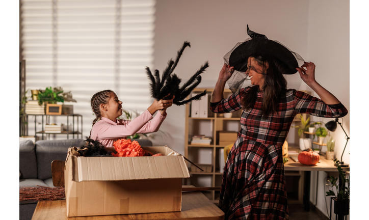 Mother and daughter unpacking a box with Halloween decorations