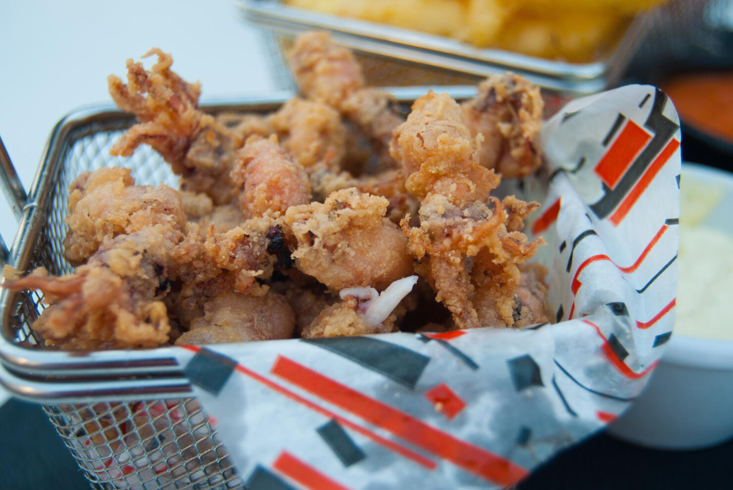 Fried squids in a small metal basket