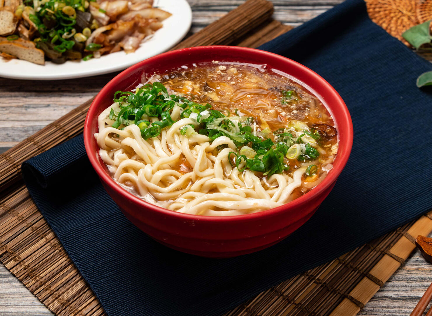 hot and sour noodles with green onion served in a bowl isolated on table top view of taiwanese food