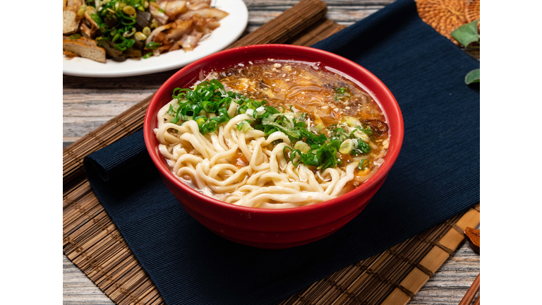 hot and sour noodles with green onion served in a bowl isolated on table top view of taiwanese food
