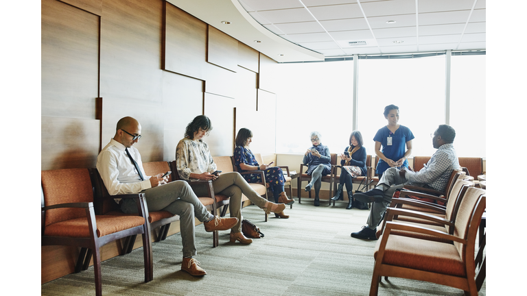 Nurse greeting patient in medical office waiting room