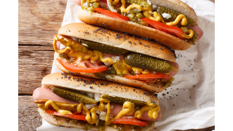 Homemade Chicago style hot dogs with mustard, tomatoes, pickled cucumbers, onions and relish close-up. Horizontal top view