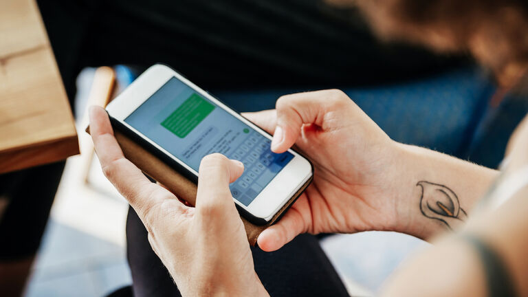 Close Up Of Woman Messaging Friends Using Smartphone