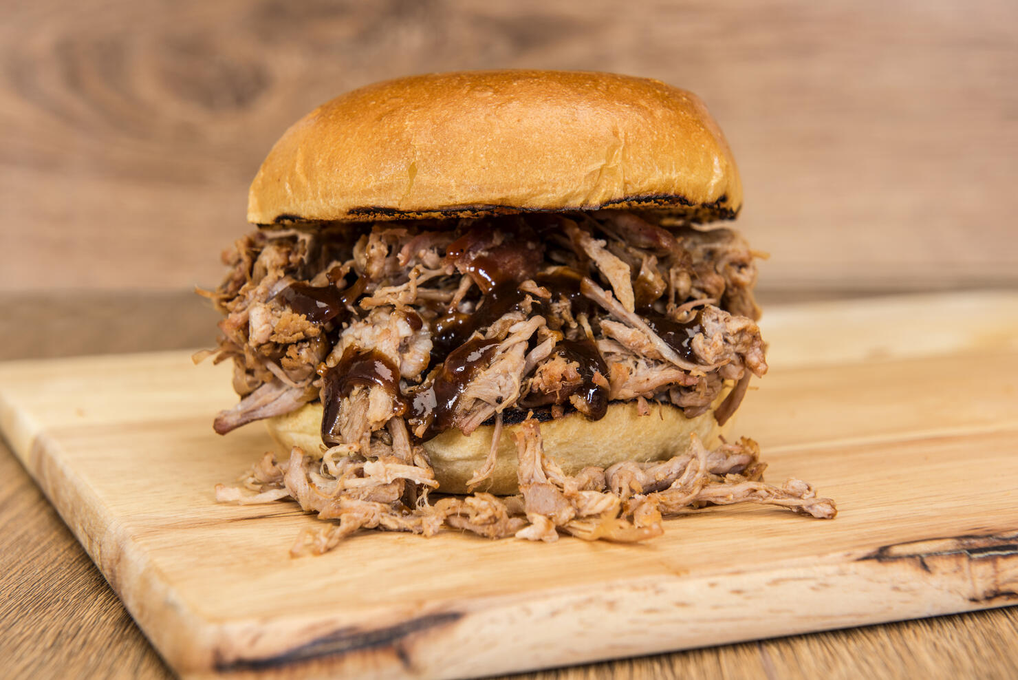 BBQ pulled pork sandwich on a wooden background