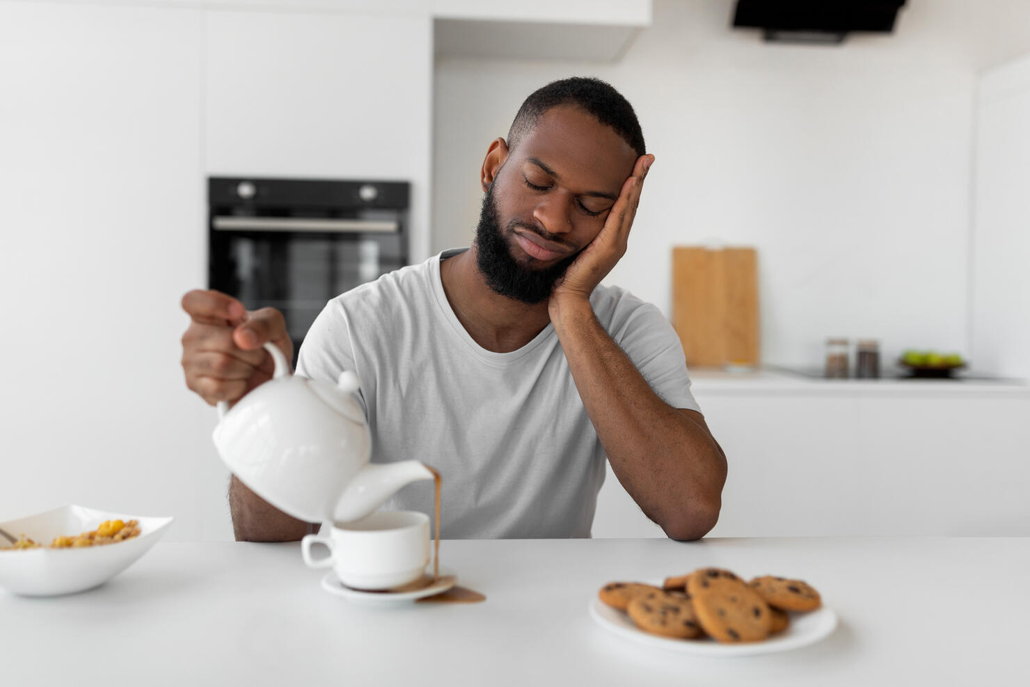 Black man pouring coffee away from cup spilling hot drink