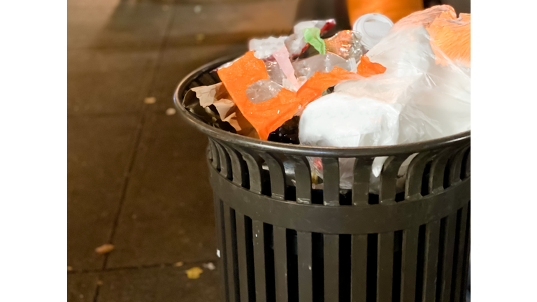 overflowing trash can on public sidewalk