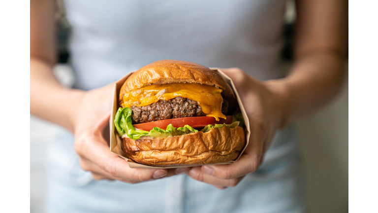 Midsection of woman holding burger