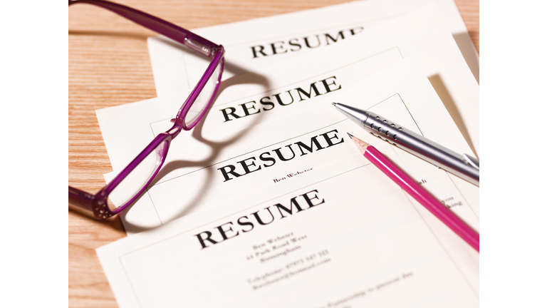 Pile of resumes with glasses and pen.