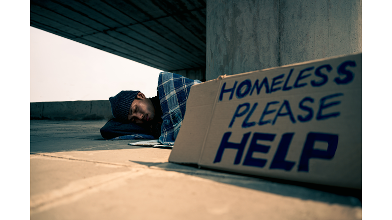 Homeless man sleeping on cardboard
