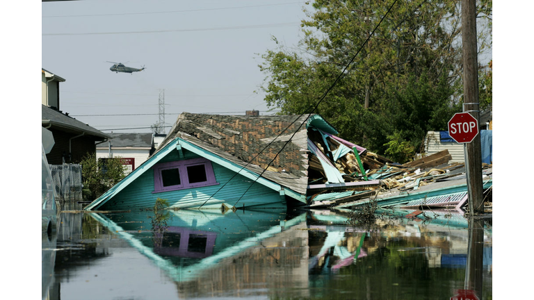 Military helicopter buzzes over the splintered remains of a 