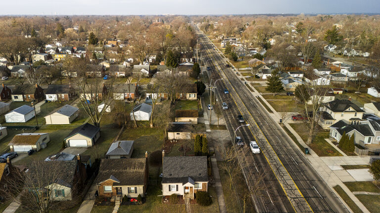 Car traffic moving through the Royal Oak neighborhood in Michigan in sunny spring day