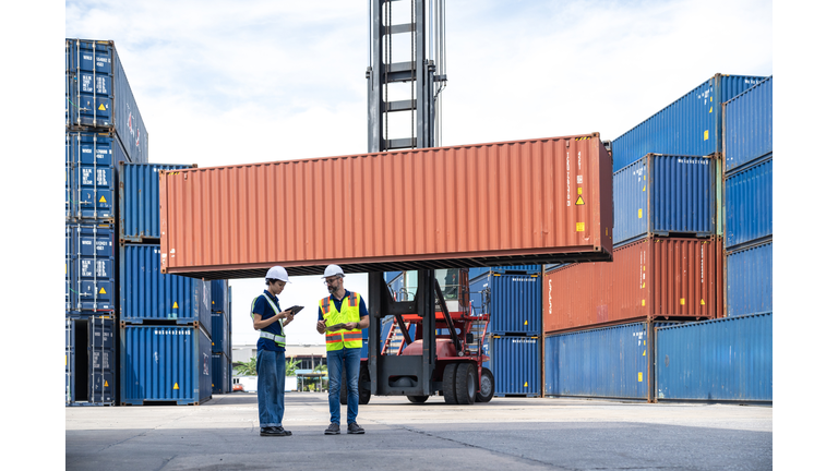 Workers are having a discussion about cargo containers