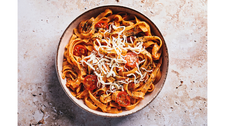 Tagliatelle with tomato sauce on stone background
