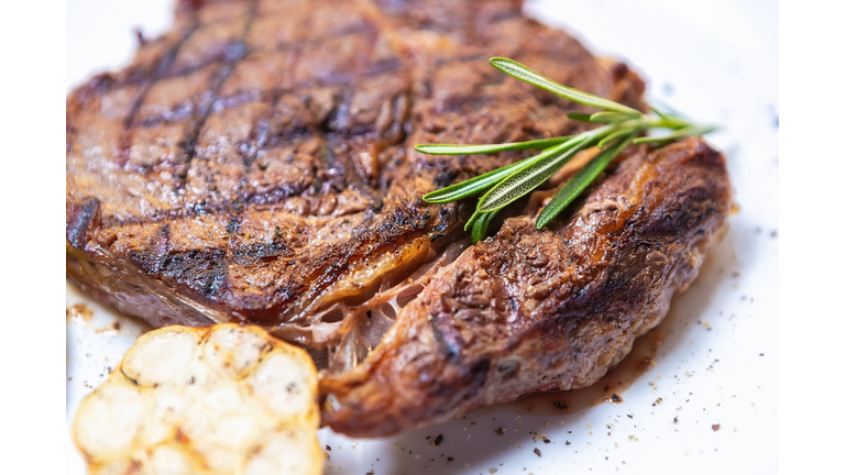 Beef meat loaf cooked on grill in restaurant and served on white ceramic plate with rosemary leaf
