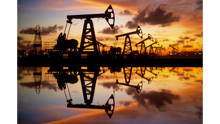 Oil Pumps And Rig At Sunset By The Sea