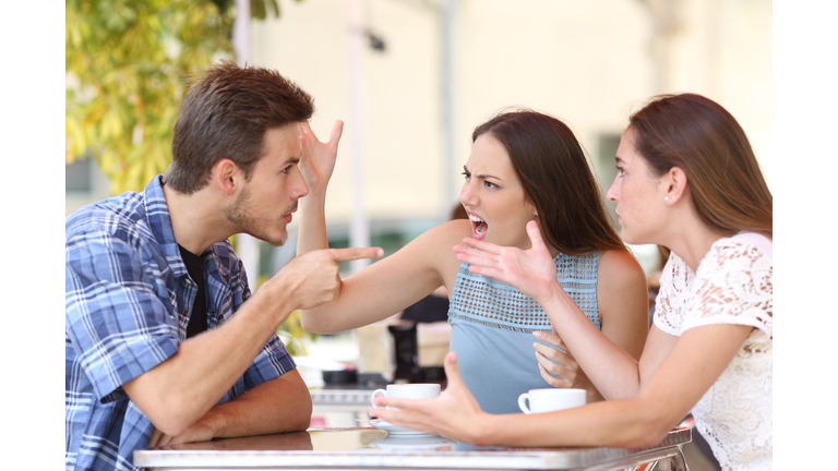 Angry friends arguing in a coffee shop