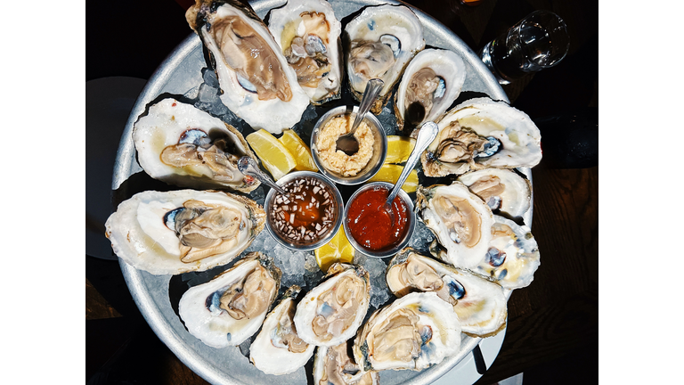 Oysters served with various sauces and lemon at the restaurant, high angle view