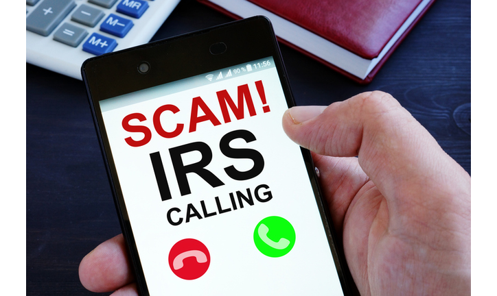 Hand is holding phone with irs scam calls.