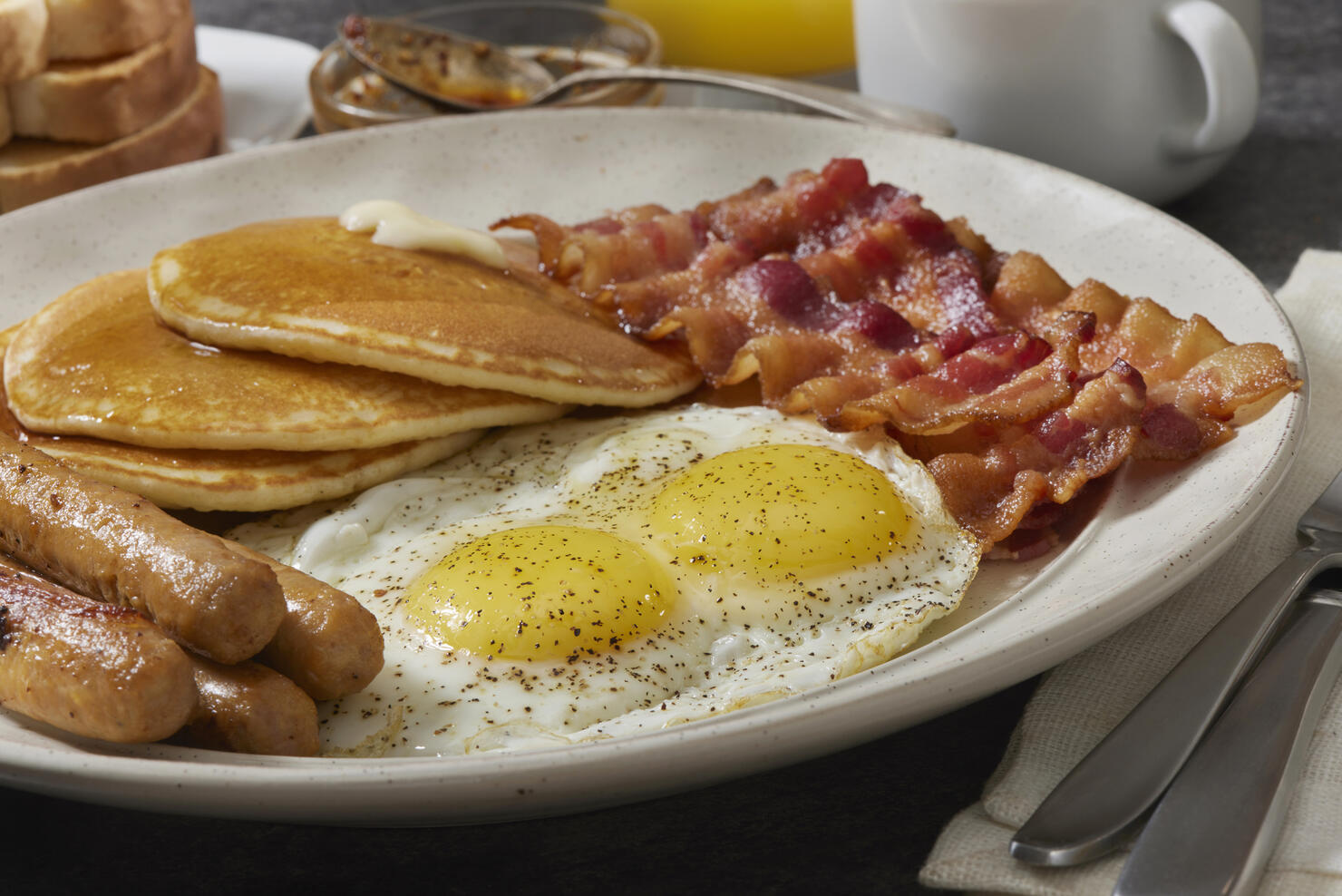 Spicy Chili Crisp Breakfast with Sunny side up eggs, Pancakes, Bacon, Sausages and Toast