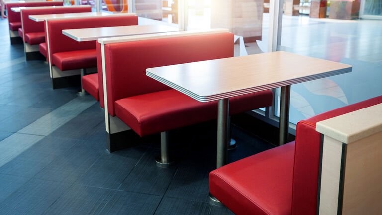 Empty fastfood restaurant interior with red chairs and table in a row