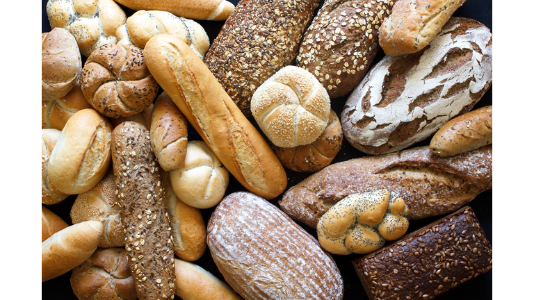Many mixed breads and rolls shot from above.