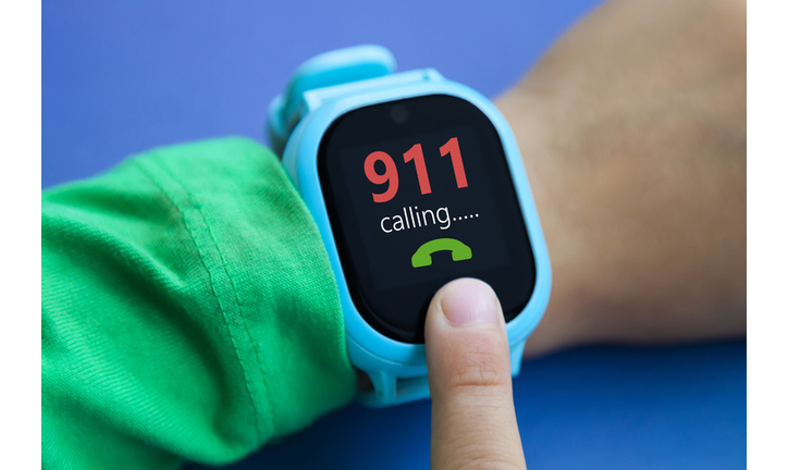 little boy calls in emergency on digital smart watch by tapping screen with his index finger. Modern children technologies. GPS tracker for kids, child tracking and parental control concept.